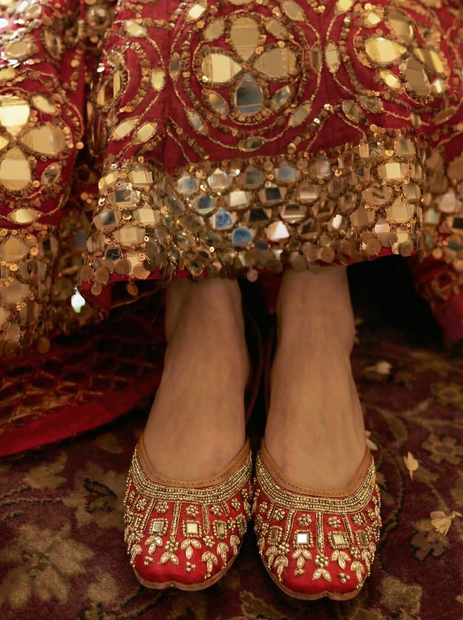 Maharani red silk bridal juttis worn with red mirror work lehenga — royal zari and mirror work handcrafted juttis by Solemates by Palak