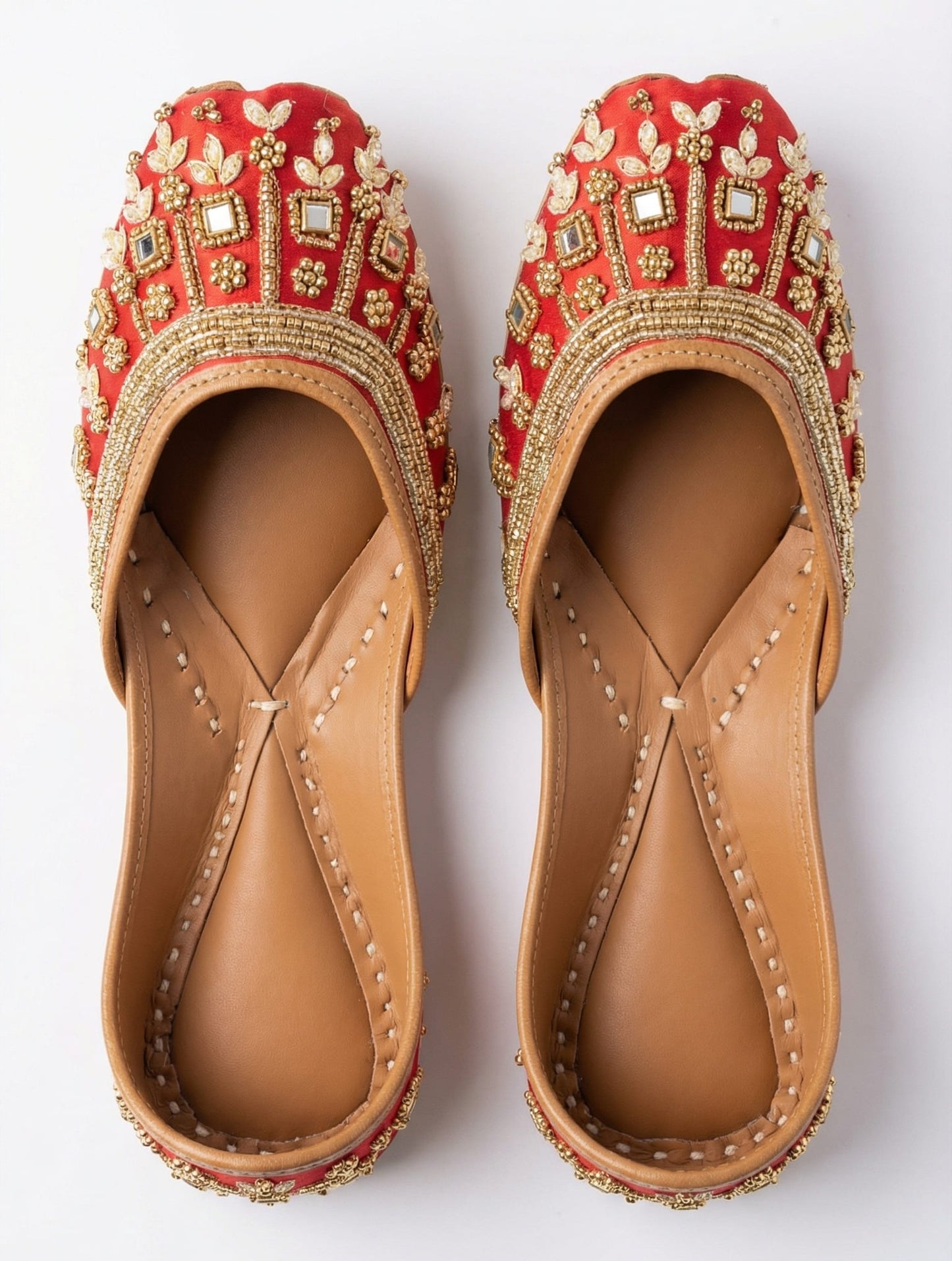 Maharani red silk juttis top view — gold zari, square mirrors, 
marquise stones and floral bead detailing by Solemates by Palak