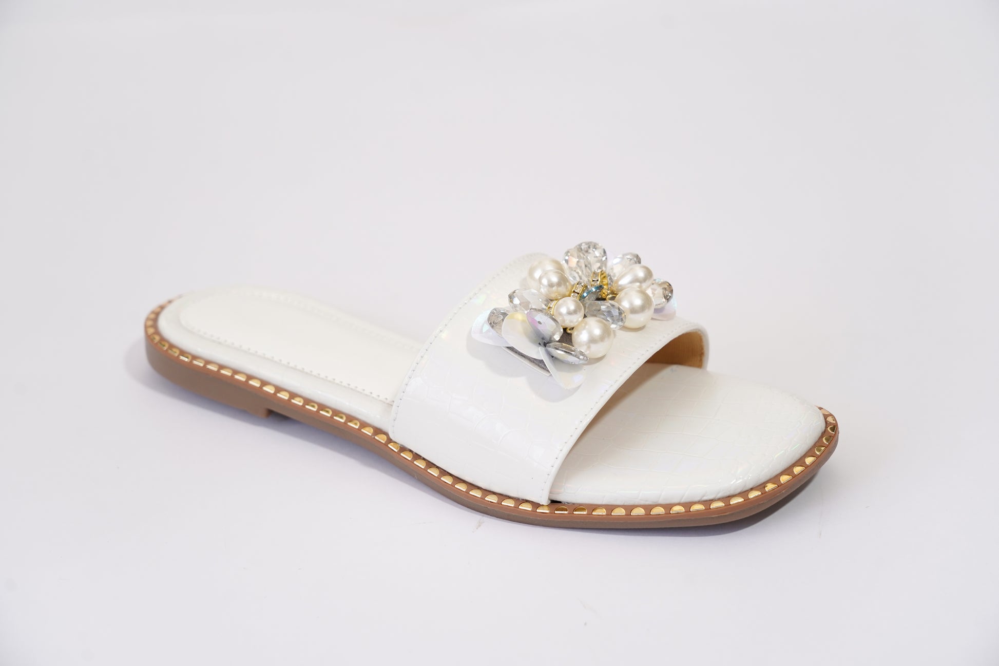 Side profile of Topaz White ivory flat slider — croc-embossed upper with pearl and crystal embellishment, gold stud sole edge, by Solemates by Palak