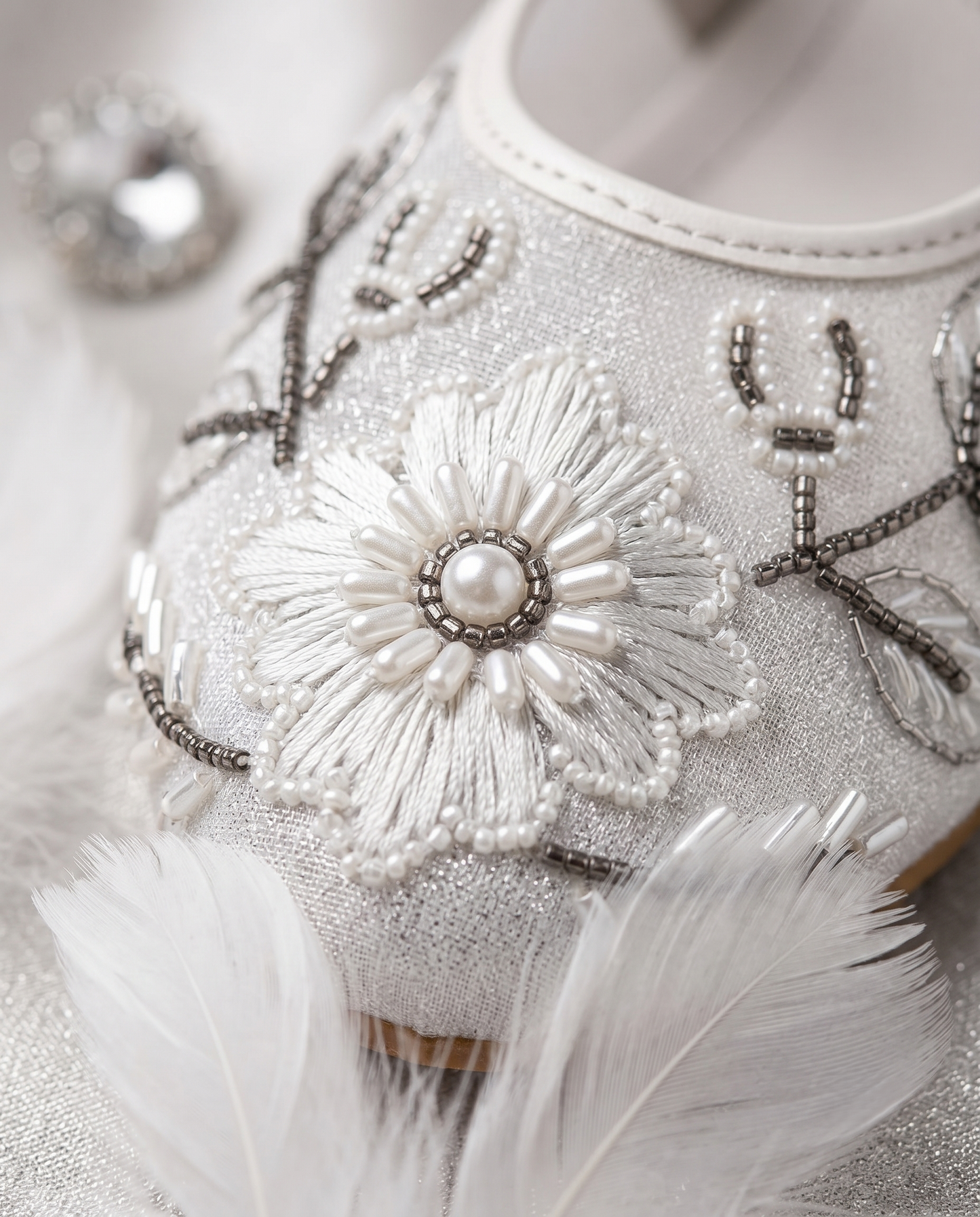The Ballet Bloom Mary Janes embellishment close-up — raised white threadwork flower with pearl centre, white seed bead petals and gunmetal grey bead vines by Solemates by Palak