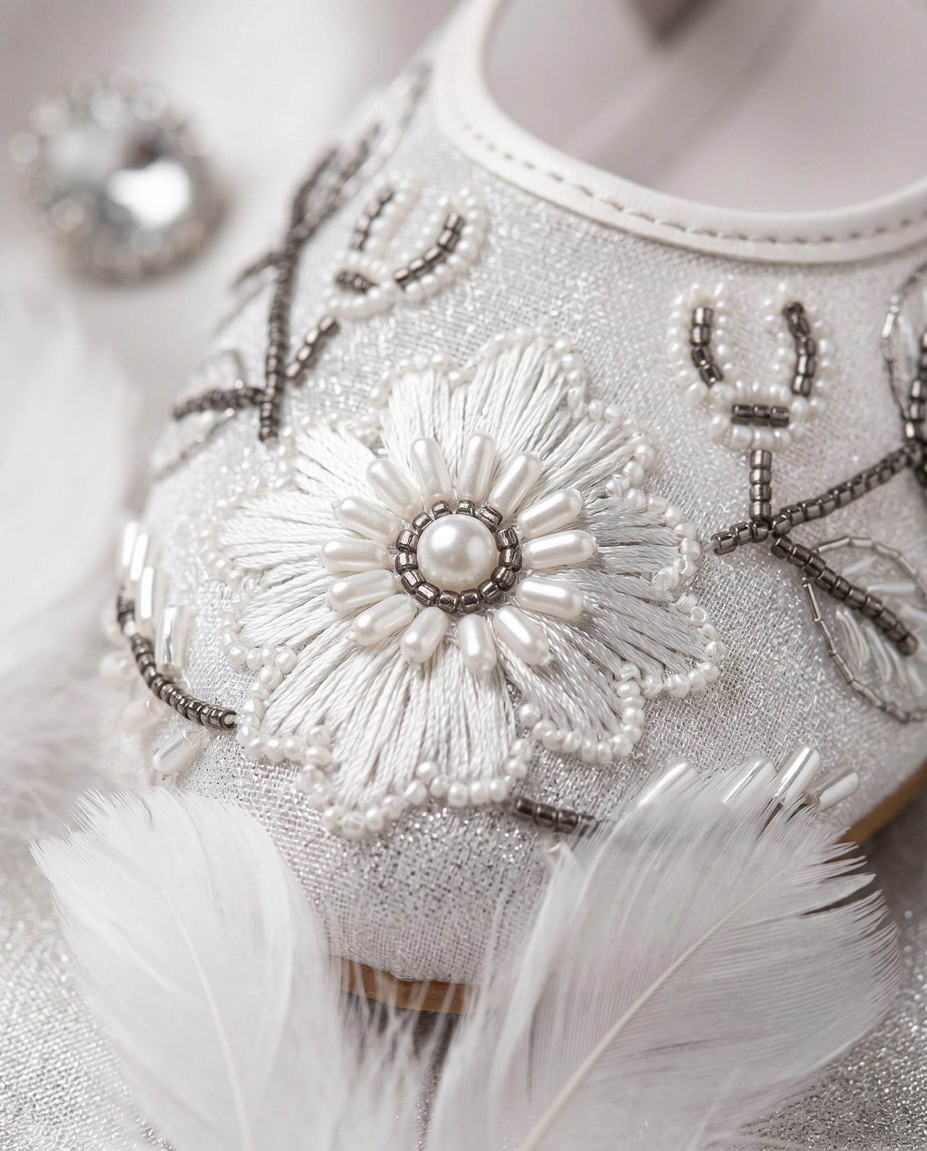 The Ballet Bloom Mary Janes embellishment close-up — raised white threadwork flower with pearl centre, white seed bead petals and gunmetal grey bead vines by Solemates by Palak