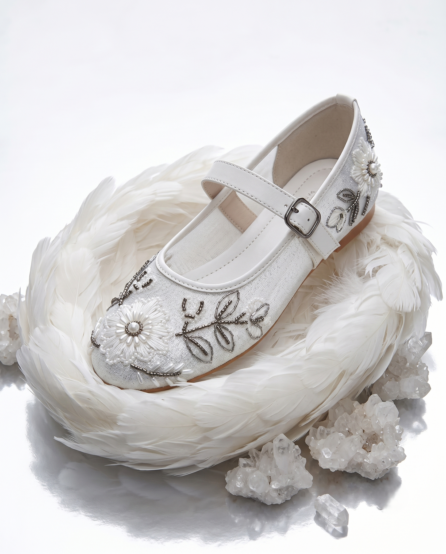 The Ballet Bloom Mary Janes nestled in white feathers with crystals — ivory shimmer Mary Jane with hand-embellished floral threadwork and pearl beads by Solemates by Palak