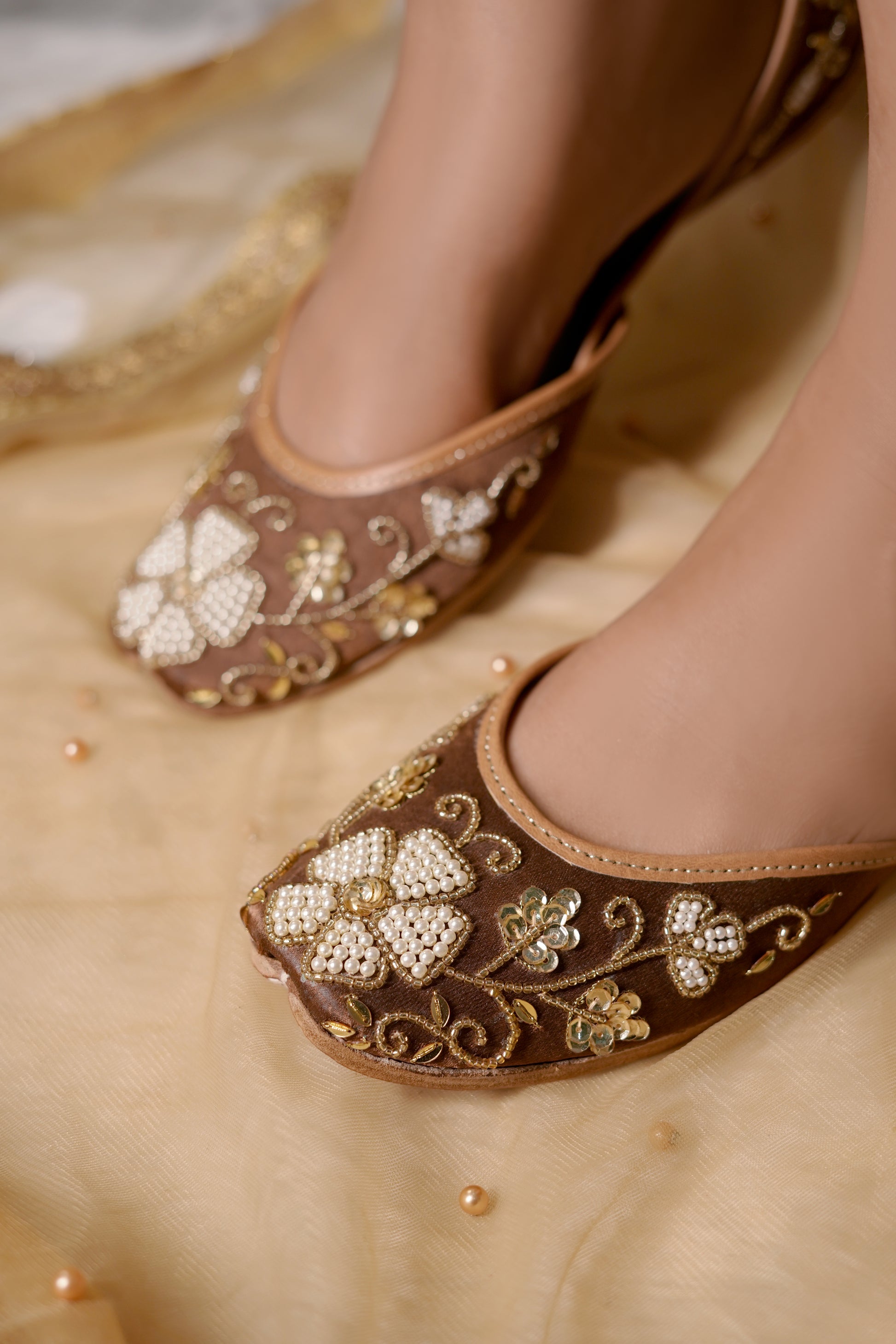 Mocha Juttis worn by model — brown velvet with pearl and 
gold sequin embellishments by Solemates by Palak