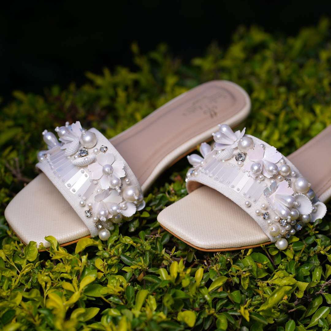 Bombshell Handcrafted Heel Sliders on green foliage — wide ivory strap with pearl clusters, 3D florals and sequin detailing by Solemates by Palak